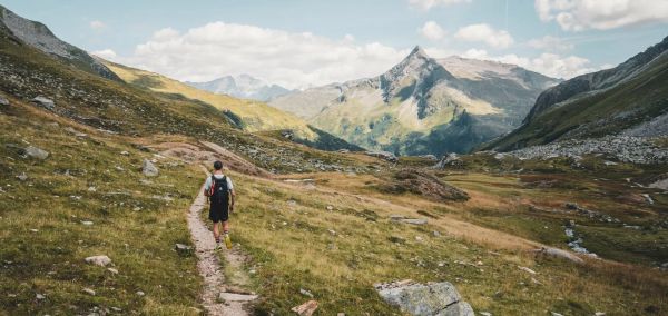 Turista procházející v létě po trase vyhlídkové stezky Hohe Tauern alpským světem hor.